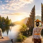 Finland and Indonesia flags beside scenic landscapes, with a woman by a Finnish lakeside and a Balinese woman carrying an offering near a traditional temple.